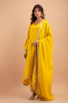 Step into the world of timeless elegance with our handcrafted Silk Kurta Set, a perfect blend of traditional grace and contemporary style. This exquisite ensemble includes a stunning kurta, a pair of breezy palazzos, and a flowing dupatta, each piece accentuated with delicate Gota lace attachments that add a touch of golden shimmer to your every move. The kurta, measuring an impressive 48 inches in length, gracefully drapes over your form, while the palazzos offer a comfortable 39-inch length fo Elegant Gold Salwar Kameez With Embroidered Border, Gold Palazzo Set For Formal Diwali Occasion, Elegant Gold Palazzo Set With Dabka, Elegant Yellow Traditional Wear For Festive Occasions, Elegant Silk Palazzo Set For Celebration, Traditional Salwar Kameez With Gota Work For Formal Occasions, Elegant Formal Dupatta With Gota Work, Formal Dupatta With Gota Work For Festivals, Elegant Gota Work Sets For Celebration