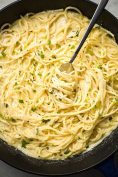 a skillet filled with pasta and topped with parsley