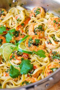 a pan filled with pasta and shrimp, garnished with cilantro