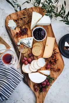 a wooden platter filled with cheese and crackers