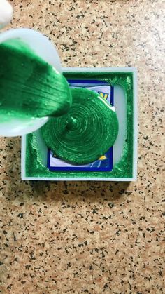 someone is painting the inside of a box with bright green paint on it and then using a brush