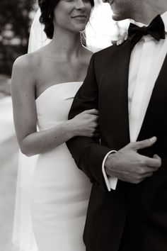 a man in a tuxedo standing next to a woman