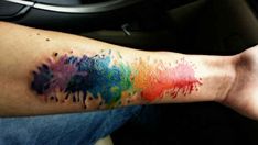 a person's arm with colorful paint splattered on it