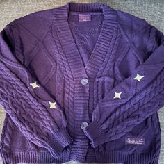 a purple cardigan sweater with stars on it