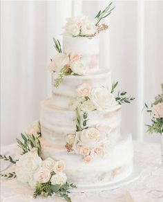 a wedding cake with white flowers and greenery