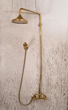 an old fashioned shower head and hand held shower faucet against a white painted wall