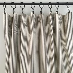 black and white striped curtains hanging on a metal rod, with the curtain pulled back