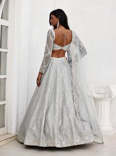 Enchant in this grey dupion silk embroidered lehenga featuring intricate mirror and zari detailing. Paired elegantly with a full-sleeve embroidered blouse and a tulle embroidered dupatta, this ensemble embodies grace and sophistication. Festive Lace Gown, Fitted Floor-length Traditional Wear With Lace Work, Festive Lace Work Organza Lehenga, Festive Organza Lehenga With Lace Work, Festive Floor-length Choli With Lace Work, Fitted Bollywood Lace Gown, Floor-length Fitted Lace Choli, Fitted Bollywood Gown With Lace Work, Bollywood Style Fitted Gown With Lace Work