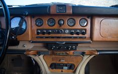 the dashboard of an old car with wood paneling and gauges on it's dash board