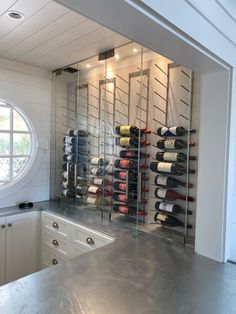 a wine cellar in the corner of a kitchen with stainless steel counter tops and white cabinets