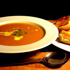 a bowl of soup and some bread on a table