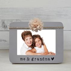 a gray frame with an image of two people and a flower on the front that says me & grandma