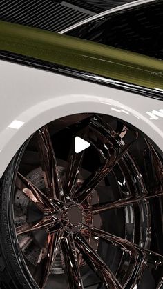 the front wheel of a white car with chrome rims