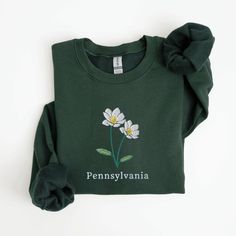 Pennsylvania State Flower Sweatshirt, Embroidered Pennsylvania Crewneck Sweater, Mountain Laurel Flower Shirt, Embroidered Pennsylvania Sweatshirt This embroidered Pennsylvania crewneck sweatshirt is everything. Perfect to show your love for the state! Please let me know if you would like extended sizing (3X-5X), I have certain color and size options available! ✨ 50% cotton, 50% polyester ✨ Pre-shrunk ✨ Classic fit Care: Machine wash: cold (max 40C or 105F) Tumble dry: low Do not iron directly o Green Embroidered Logo Sweatshirt For Spring, Green Sweatshirt With Embroidered Logo For Spring, Green Spring Tops With Embroidered Logo, Green Spring Top With Embroidered Logo, Spring Green Tops With Embroidered Logo, Spring Green Top With Embroidered Logo, Green Embroidered Long Sleeve T-shirt, Green Embroidered Relaxed Fit Sweatshirt, Green Crew Neck Sweatshirt With Floral Embroidery