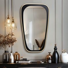 a black and gold mirror on the wall above a dresser