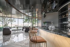 a bar with chairs and tables in front of a large glass window overlooking the city