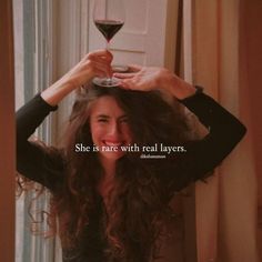 a woman holding a glass of wine in front of her face with the caption she is rare with real layers