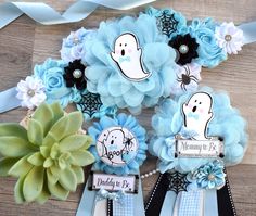 some paper flowers are sitting on a table next to ribbons and ribbon clips with ghost decorations