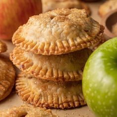 apple pies stacked on top of each other next to an apple and some cookies