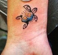 a small tattoo on the wrist of a person with an orange and blue fish in it