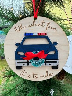 a wooden ornament with a police car on it's side hanging from a christmas tree