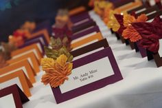 there are many place cards that have leaves on them and name tags attached to them