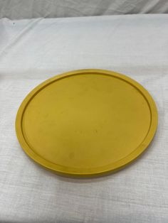 a yellow plate sitting on top of a white table cloth