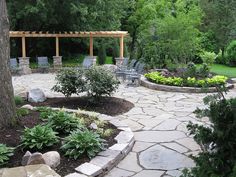 a stone patio surrounded by trees and chairs