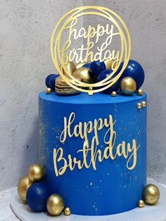 a blue birthday cake with gold decorations on top