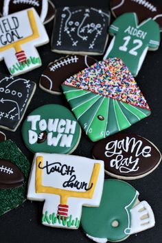 some decorated cookies are sitting on a black table together with the words touch and win written on them