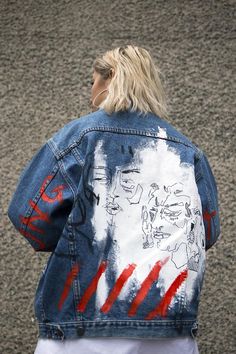 the back of a woman's jean jacket with red, white and blue designs on it