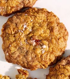 several cookies on a white surface with one cookie broken in half and the other whole