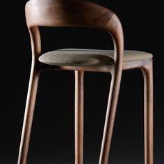 two wooden stools sitting next to each other on a black background, one with a seat and the other without