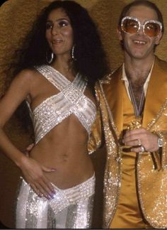 the man and woman are dressed up in disco outfits