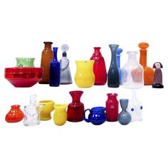 many different colored glass vases and bowls