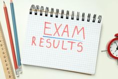 a notepad with the words exam results next to an alarm clock and pencils