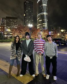 three young people standing next to each other on a sidewalk