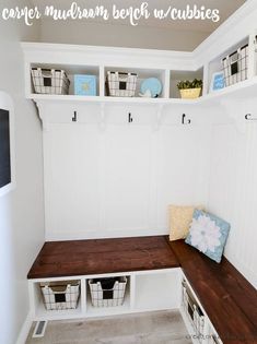 a white mudroom with wooden bench and cubbies