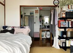 a bedroom with a bed, bookshelf and mirror