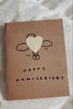 an anniversary card with a hot air balloon floating in the sky on top of it