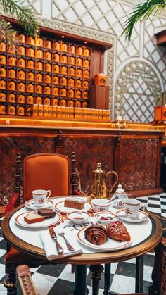 a table with plates and cups on it in front of a checkerboard floor