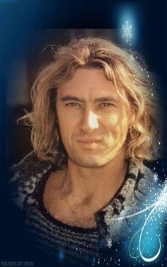 a man with long blonde hair wearing a sweater