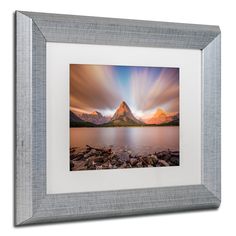 an image of a mountain in the sky with clouds above it and water below it