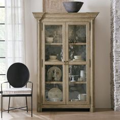 an old china cabinet with glass doors in a living room