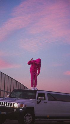 a person in pink is standing on top of a hummer