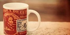 a red and white coffee mug sitting on top of a table