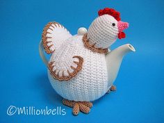 a crocheted chicken sitting on top of a tea pot