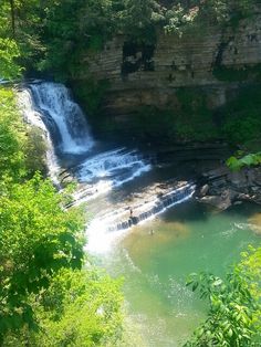 a large waterfall in the middle of a forest