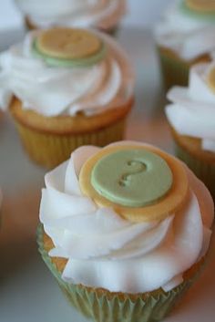 cupcakes with white frosting and green buttons on them