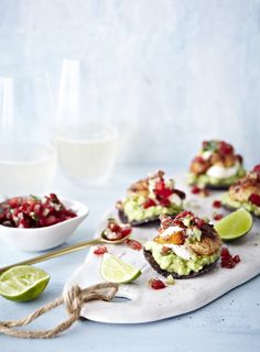 small appetizers are served with limes and cranberry salsa